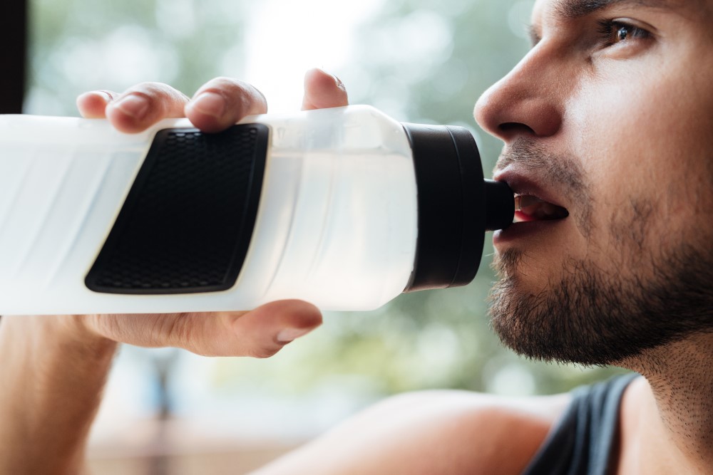 Close up of a man drinking water at the gym